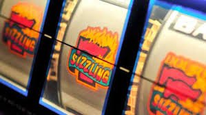 Dealer kasino live berinteraksi sambil bermain baccarat dengan latar studio yang modern
